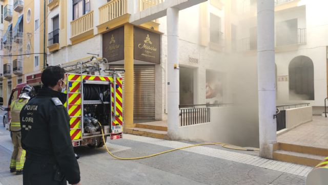 Efectivos de Policía Local y Bomberos de Lorca extinguen un pequeño incendio que se ha producido en un vehículo estacionado en un garaje de la calle Murillo